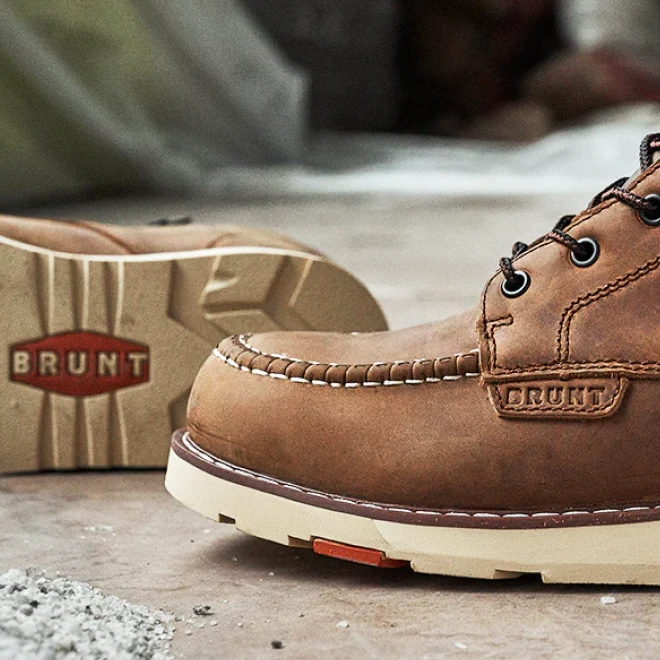 Close-up of brown leather Brunt work boots with white soles on a concrete floor.